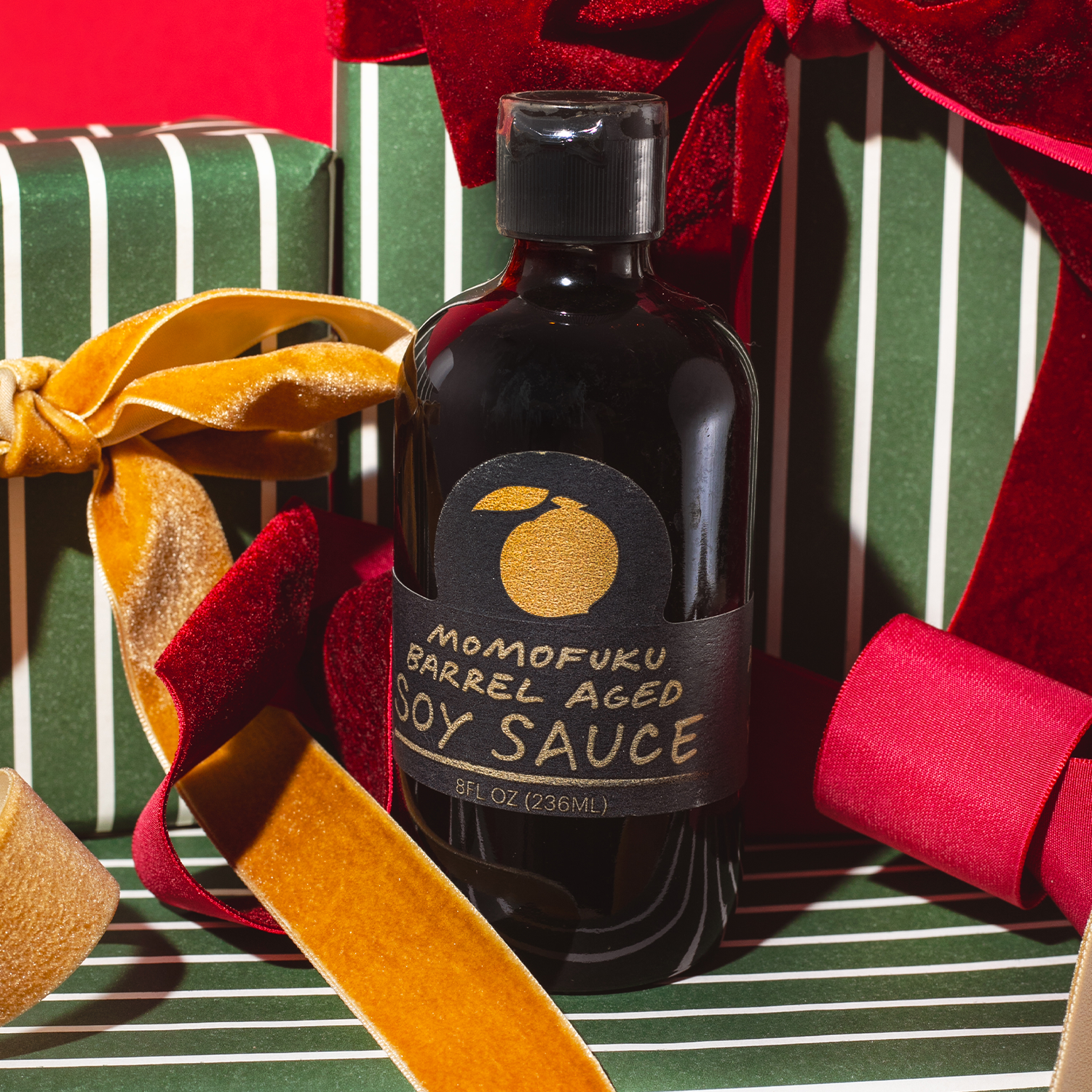 Bottle of Momofuku Barrel Aged Soy Sauce on a festive background with ribbons.