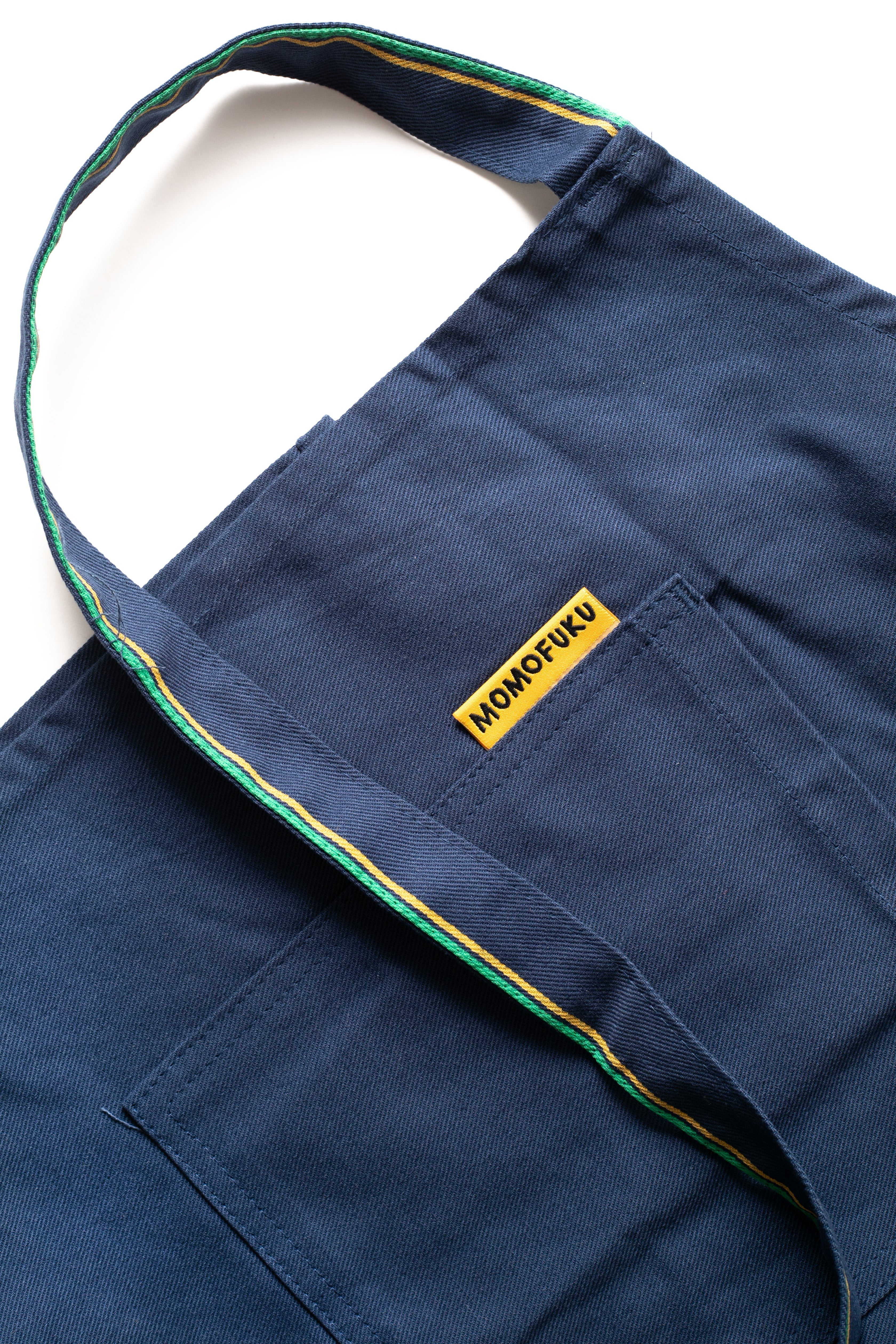 Close up of Momofuku Apron pocket with Momofuku Branded tag